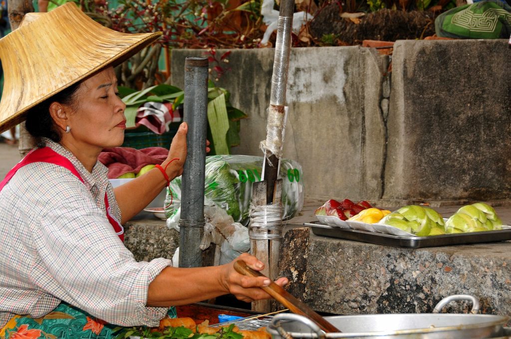 丹嫩沙多水上市场船上售卖食物的小贩