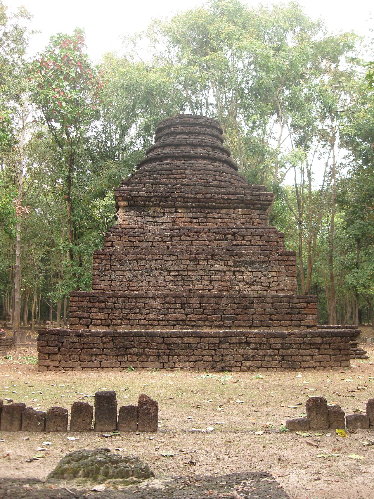 甘烹碧森林区寺庙遗址,佛塔隐没在树林中,适合说明阿兰伊克区氛围
