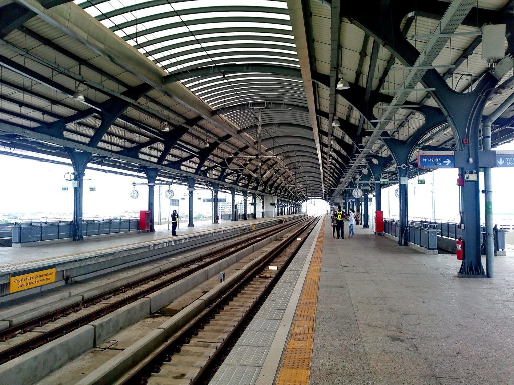 白天的廊曼SRT红线高架站台、双向轨道与出口标识