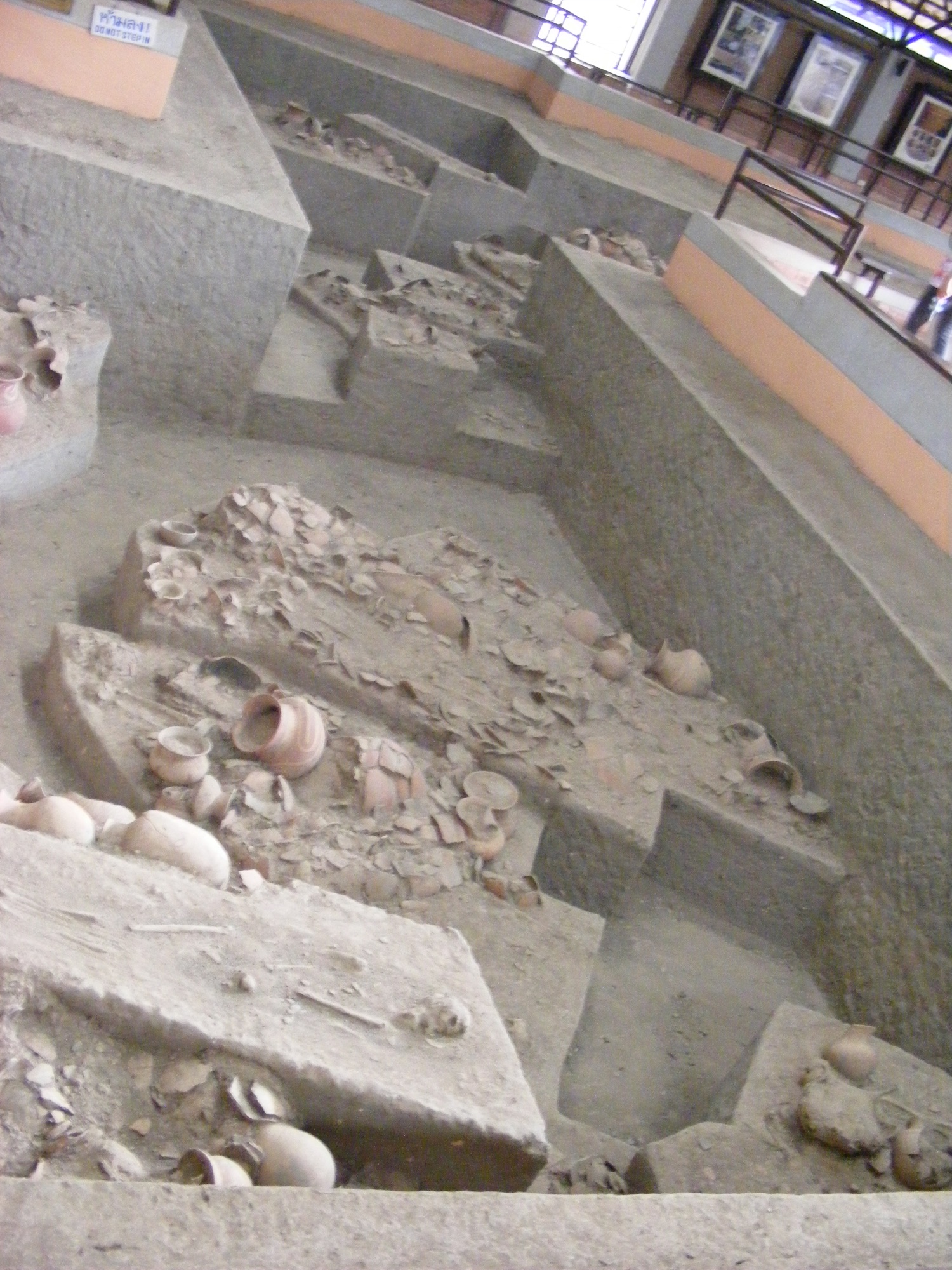 诗奈寺发掘复原展示的土台陶器、坑边围栏与墙上照片
