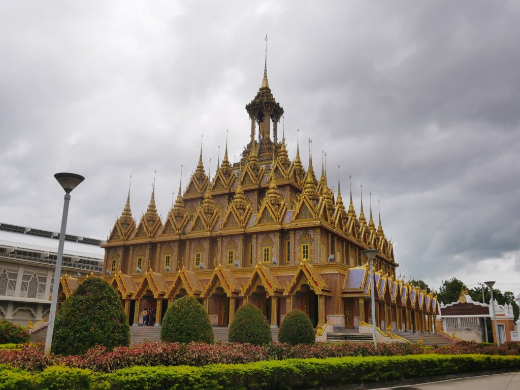 从侧前方看塔桑寺金色城堡，尖顶与回廊沿建筑展开