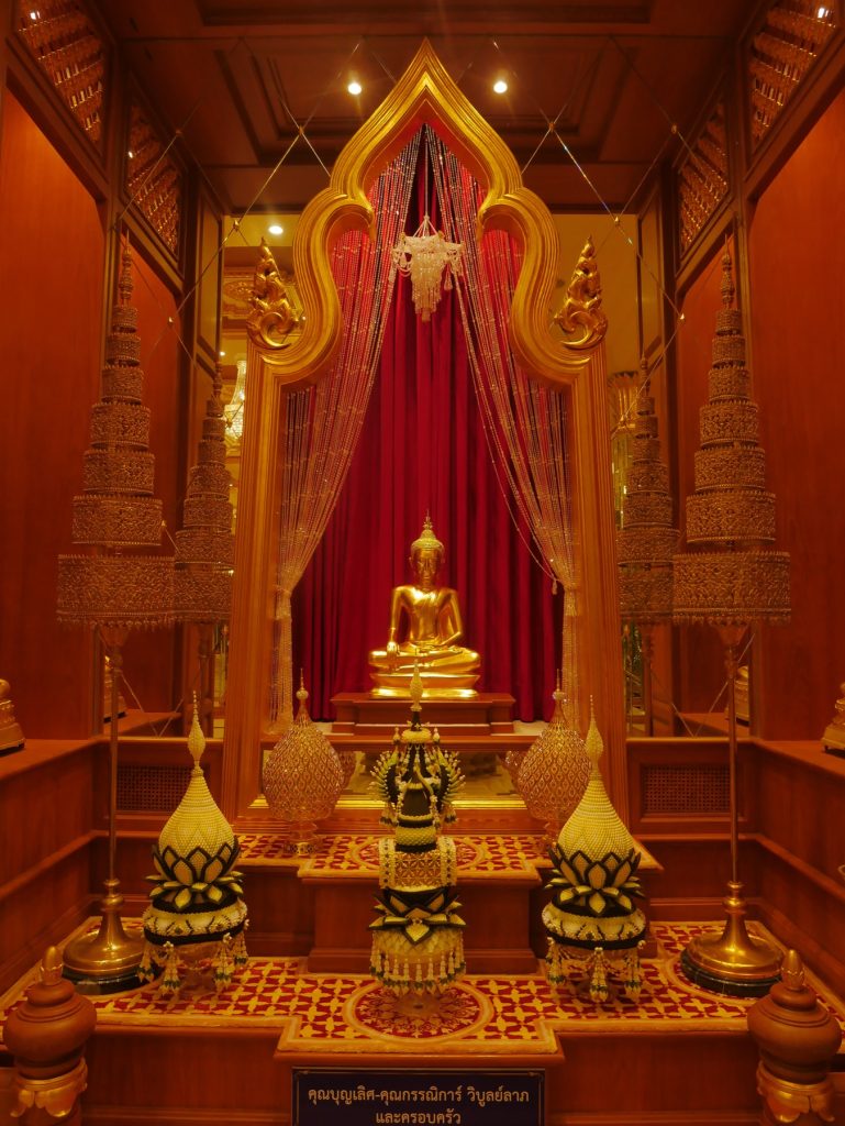 塔桑寺木质佛龛内的金色坐佛，背后垂着红色帘幕