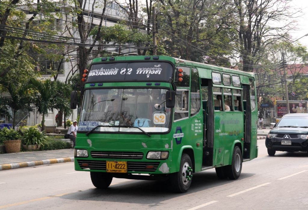 曼谷街道上迎面驶来的绿色 82 路小型公交车