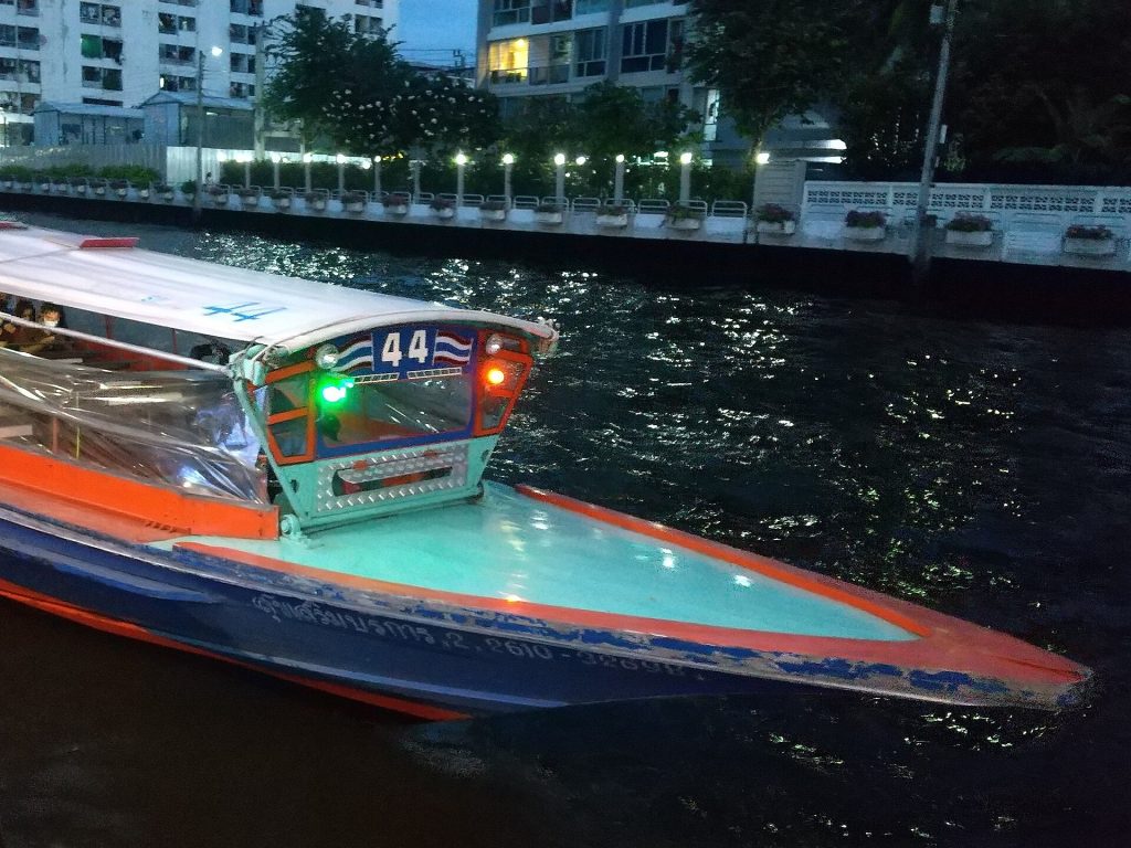 夜间停靠The Mall Bang Kapi码头的空盛桑运河快船船头