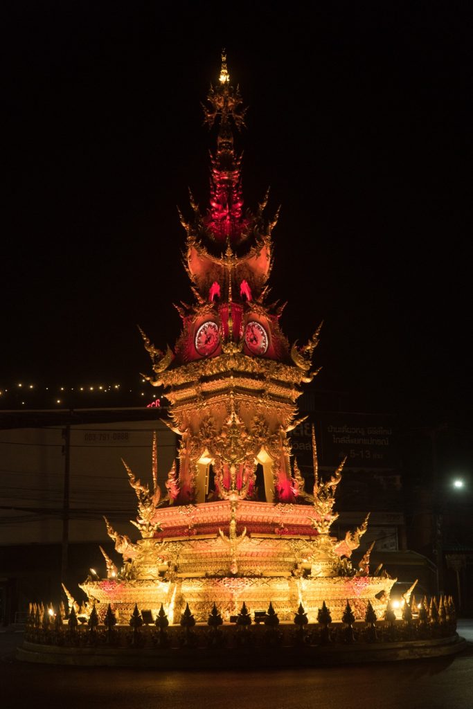 夜间亮起红金灯光的清莱钟楼与黑色天空