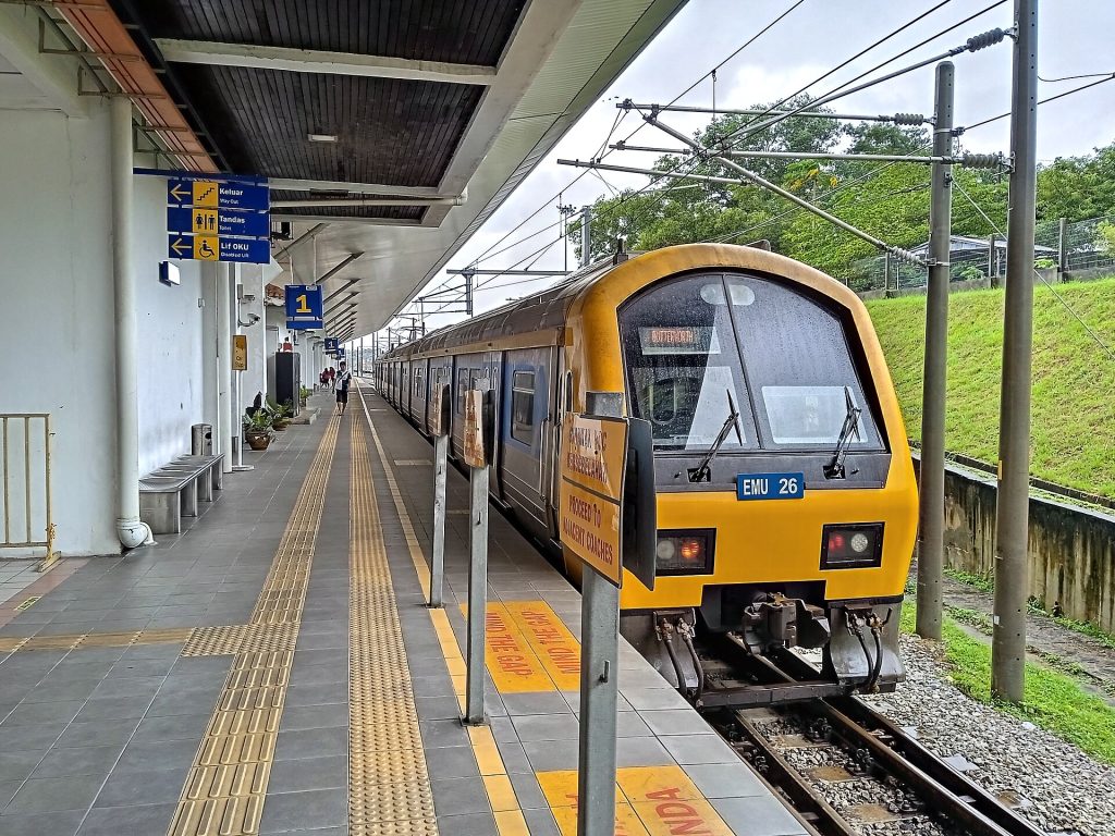 巴东勿刹KTM一号站台停着黄银色列车，地面有黄色导向线