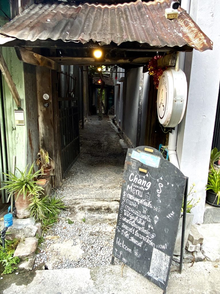 宋卡老城铁皮屋檐下通往店铺的窄巷、石阶与手写菜单牌