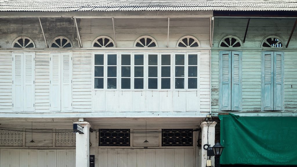 宋卡老城浅色木店屋立面、百叶门窗和拱形窗楣