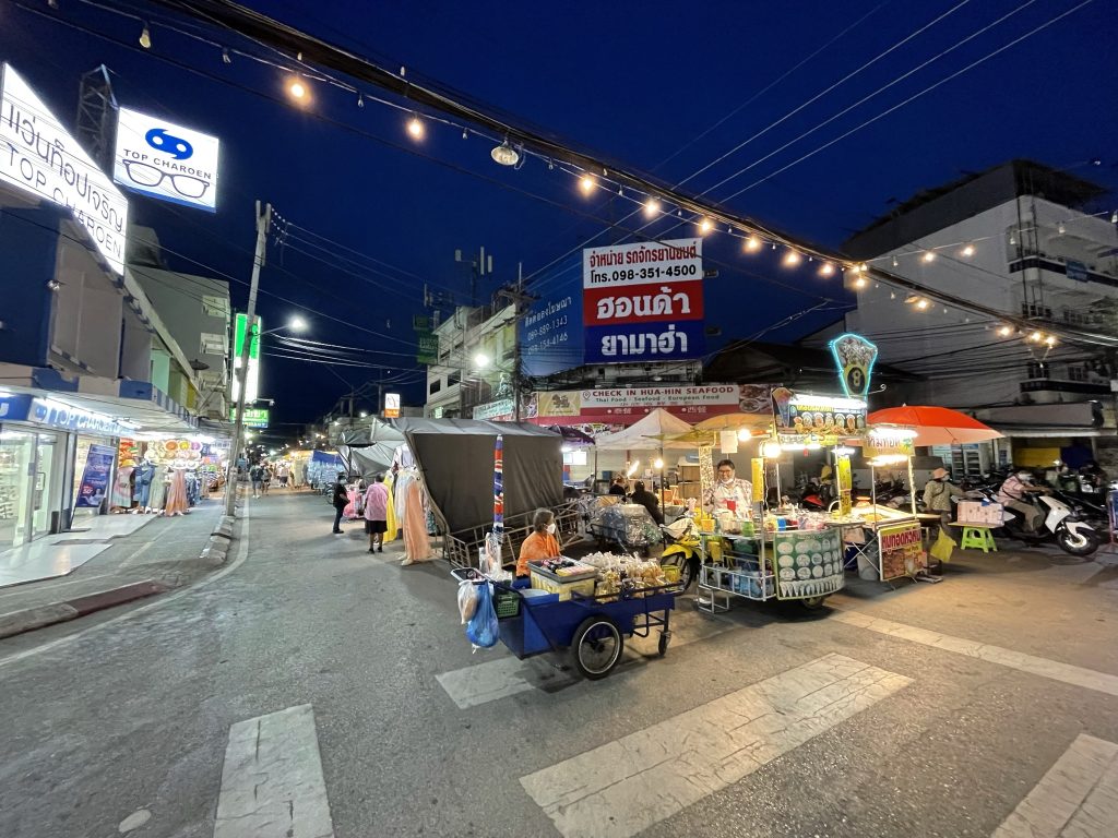 夜色中华欣夜市街道两旁亮灯的摊位与行人