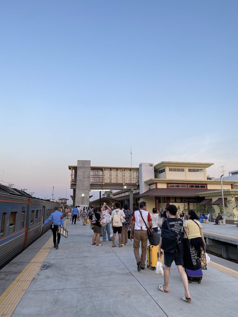 傍晚佛统火车站站台上拉着行李的旅客