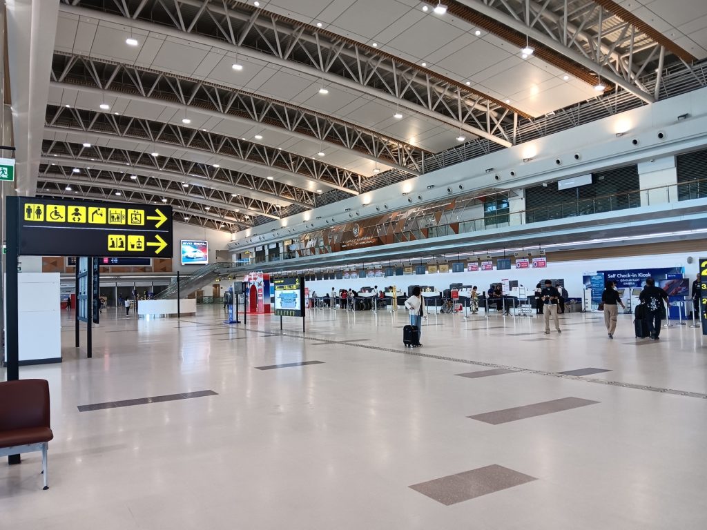 洛坤机场航站楼内部的值机柜台、导向牌和开阔大厅
