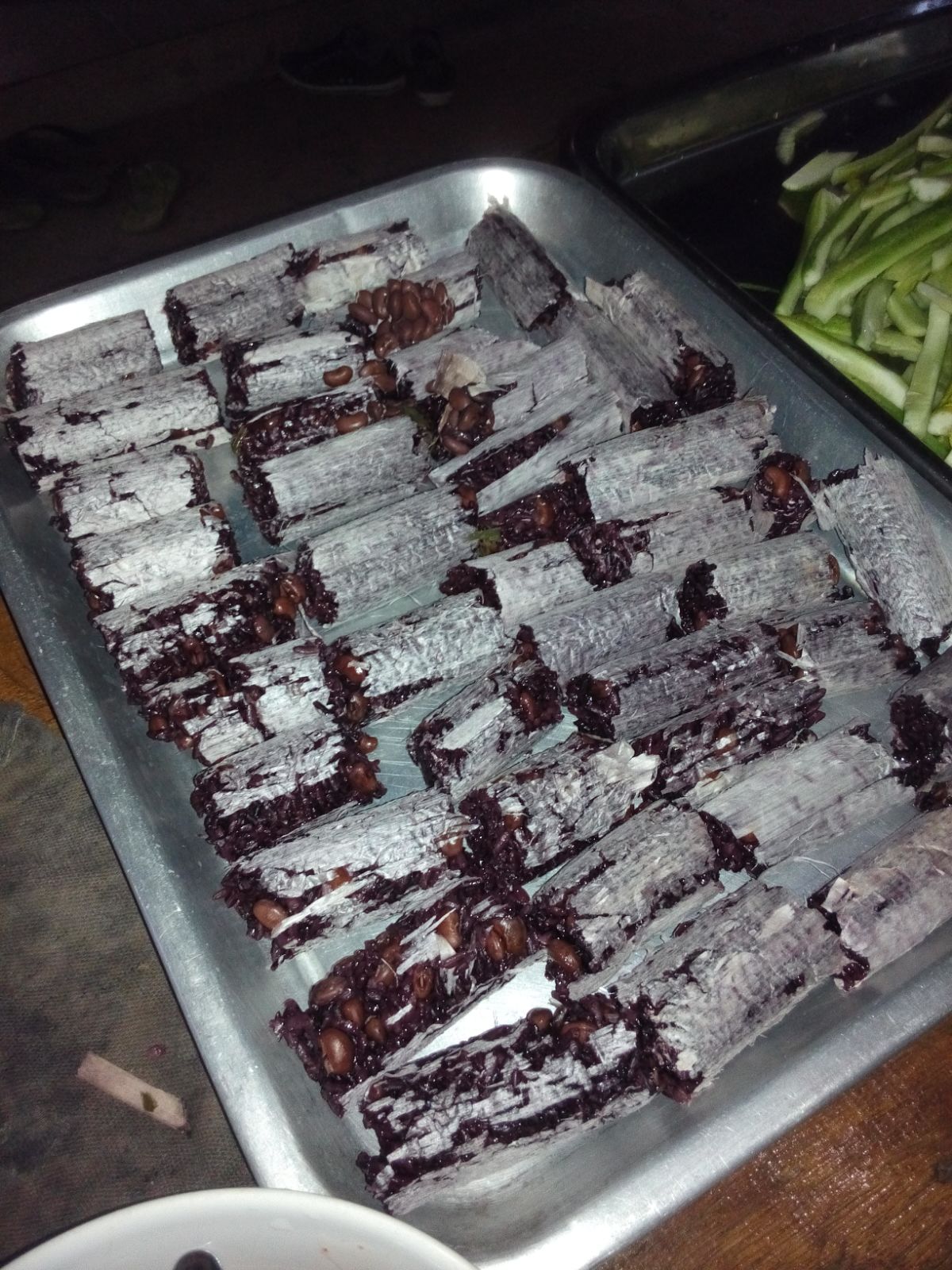 托盘里多段深色竹筒饭，外侧留有浅色薄层，拍摄地点不明