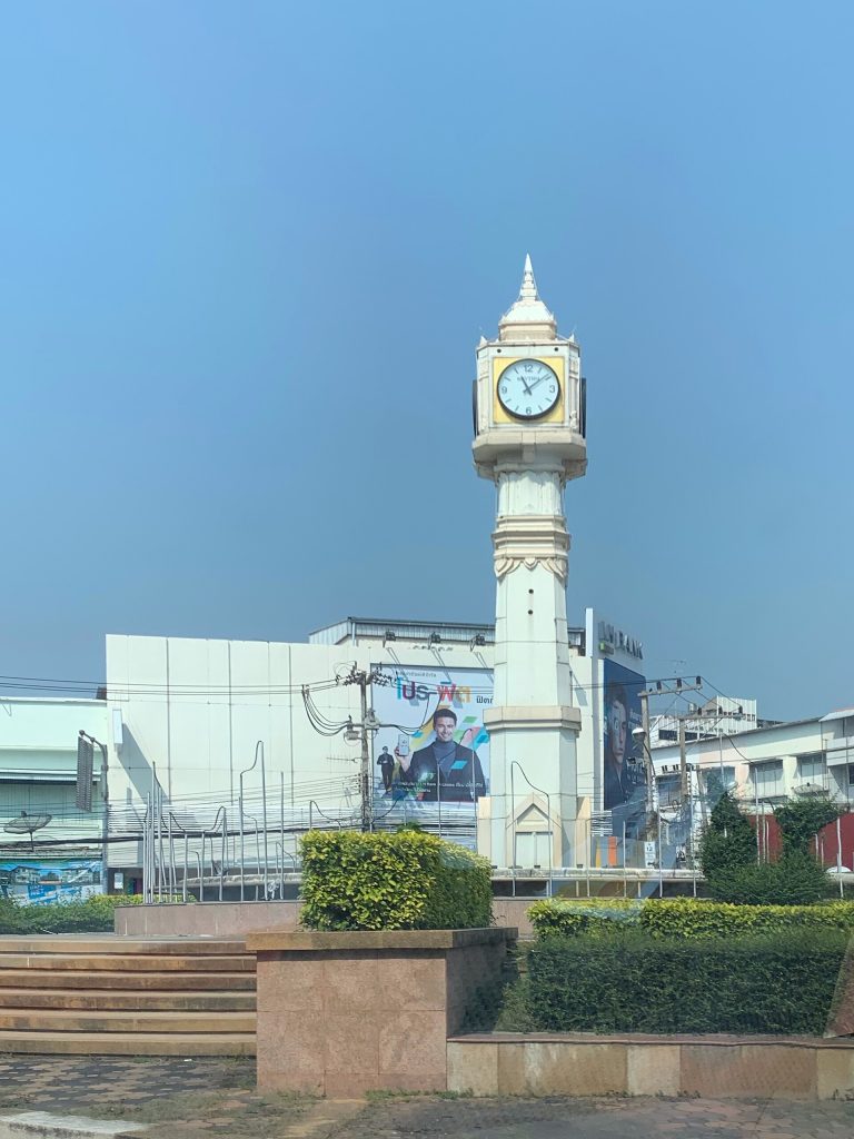 蓝天下的彭世洛钟楼、绿篱与周边建筑