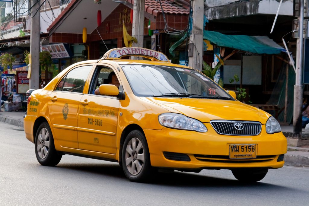芭提雅街头一辆黄色出租车，车顶装有 TAXI-METER 标牌