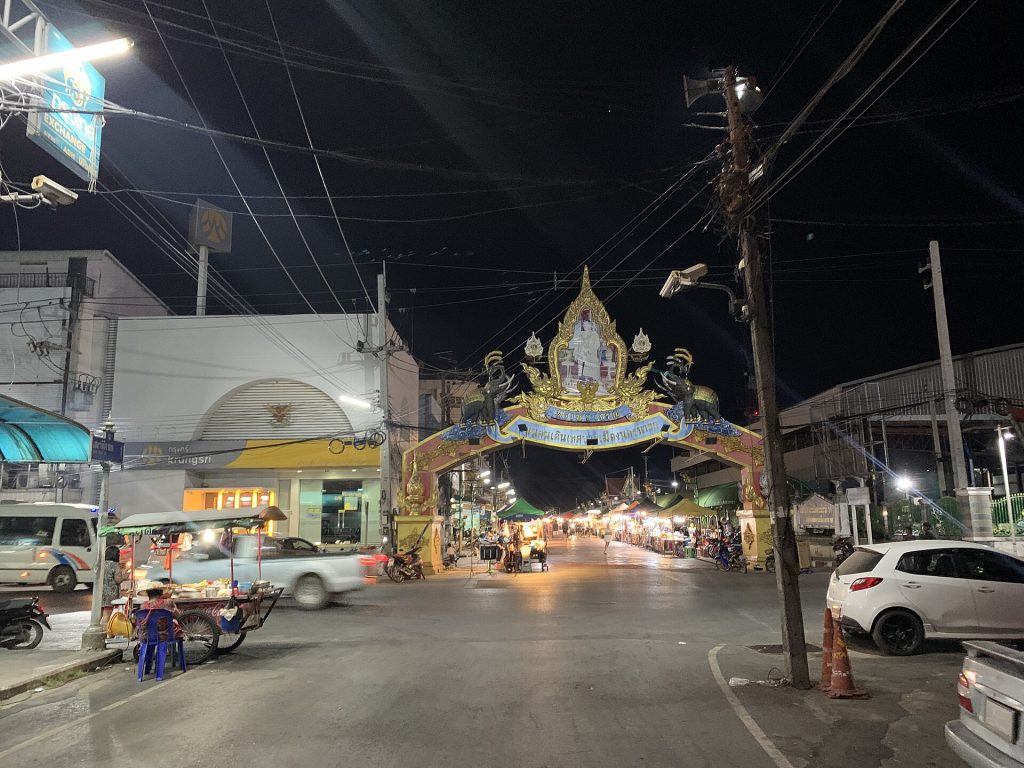 夜间那空那育市镇步行街入口与道路两侧摊位