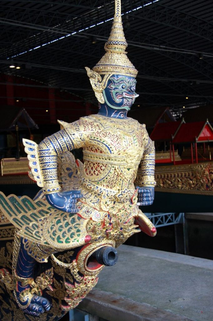 馆内一尊蓝色面孔、戴尖冠的鸟身人物船头雕饰，金色衣纹间嵌有彩色装饰。
