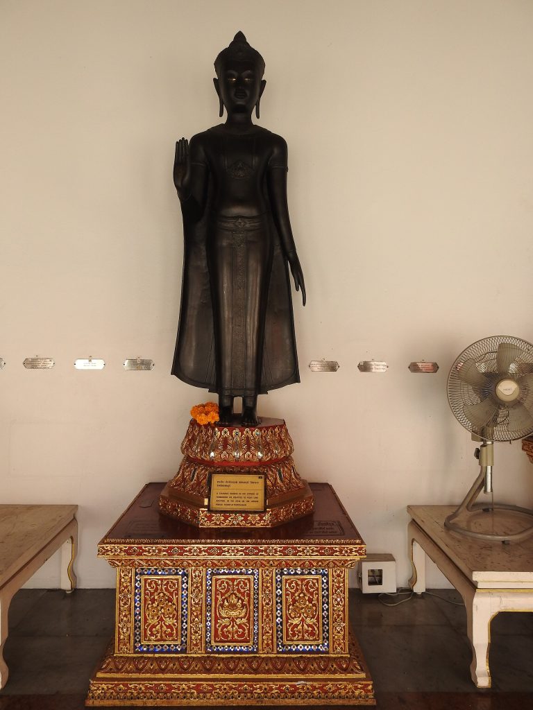 云石寺回廊中的一尊站立佛像，画面不展示整段回廊。