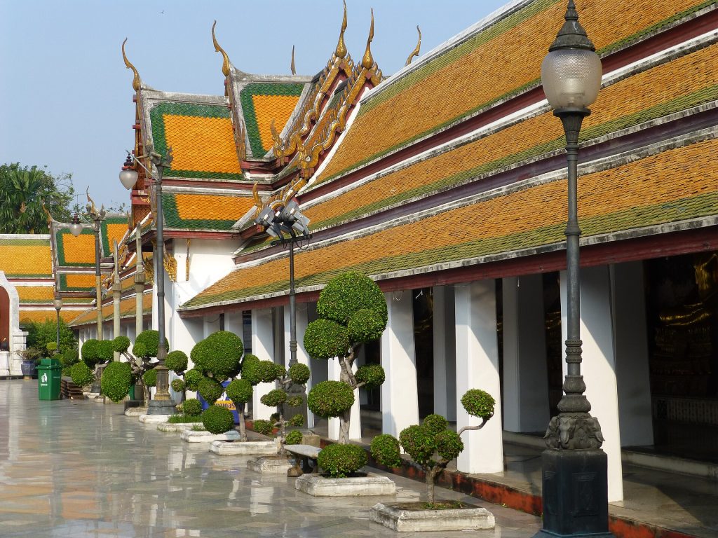 苏泰寺主佛殿外侧的回廊，白色柱列在橙绿瓦屋檐下向远处延伸。