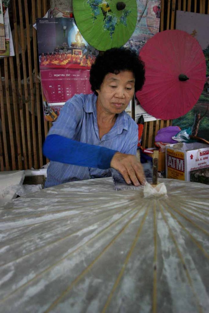 泰国制伞工人正在处理展开的浅色伞面