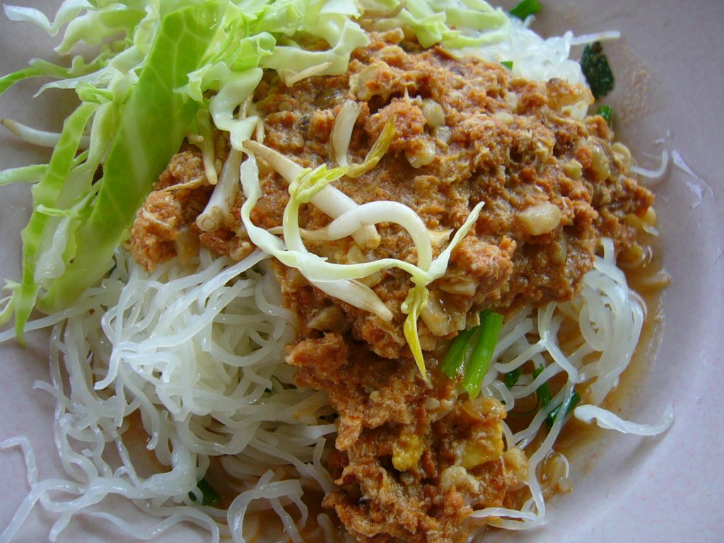 白色米线上浇着鱼肉酱并配卷心菜和豆芽