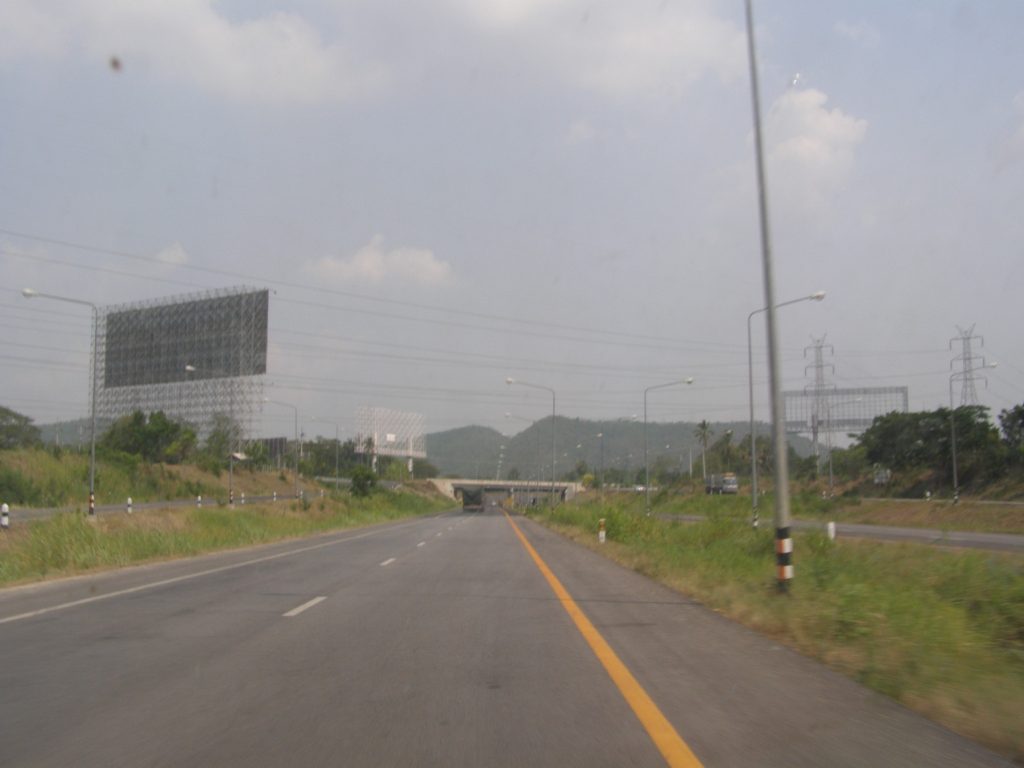 那空沙旺郊外通往城区的分隔道路、路灯与远处山丘