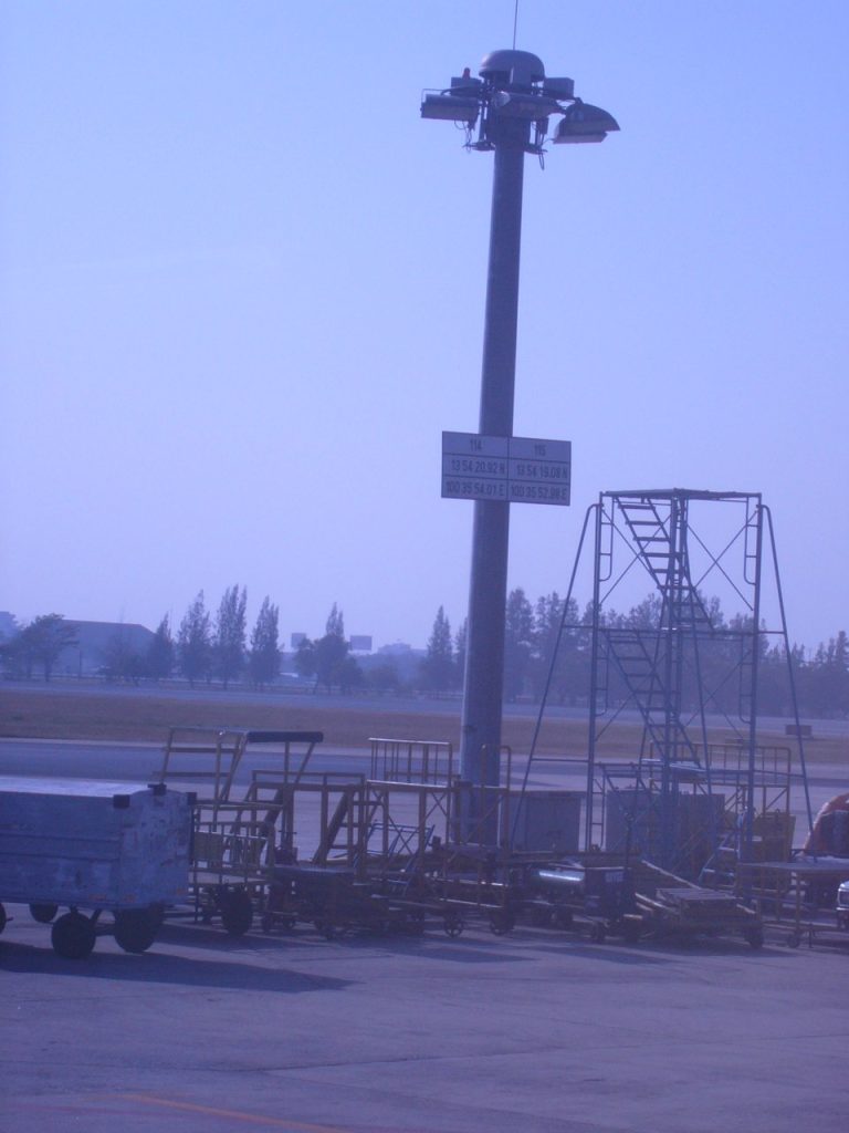 色军机场停机坪边的高杆灯与地勤拖车