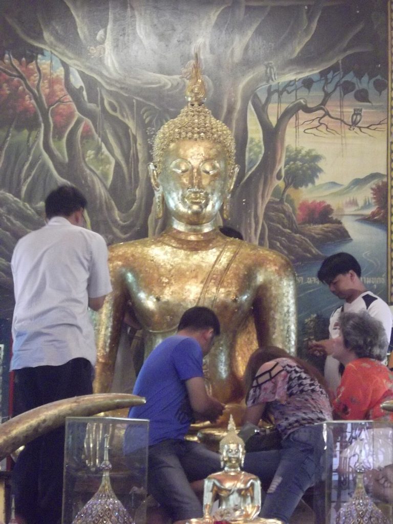 挽披大内寺参拜者在贴金坐佛前停留