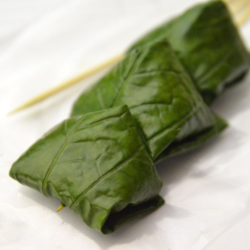 已折合的一只绿色 Miang Kham 叶包近景