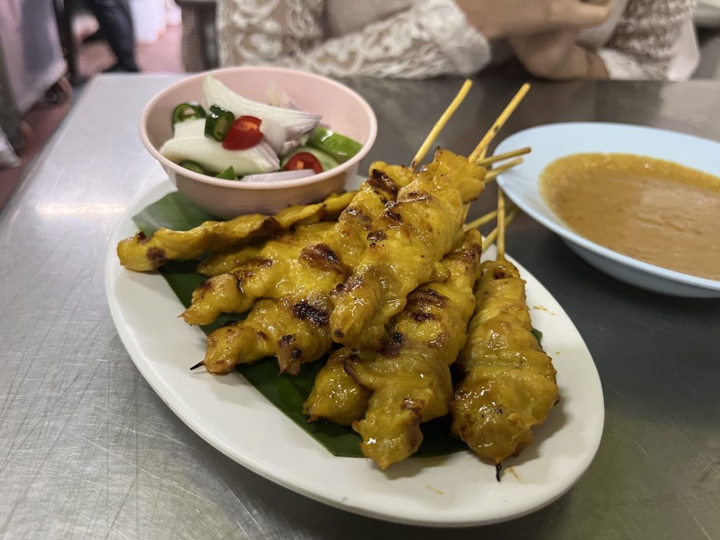 黄色猪肉沙爹肉串与黄瓜葱片配菜