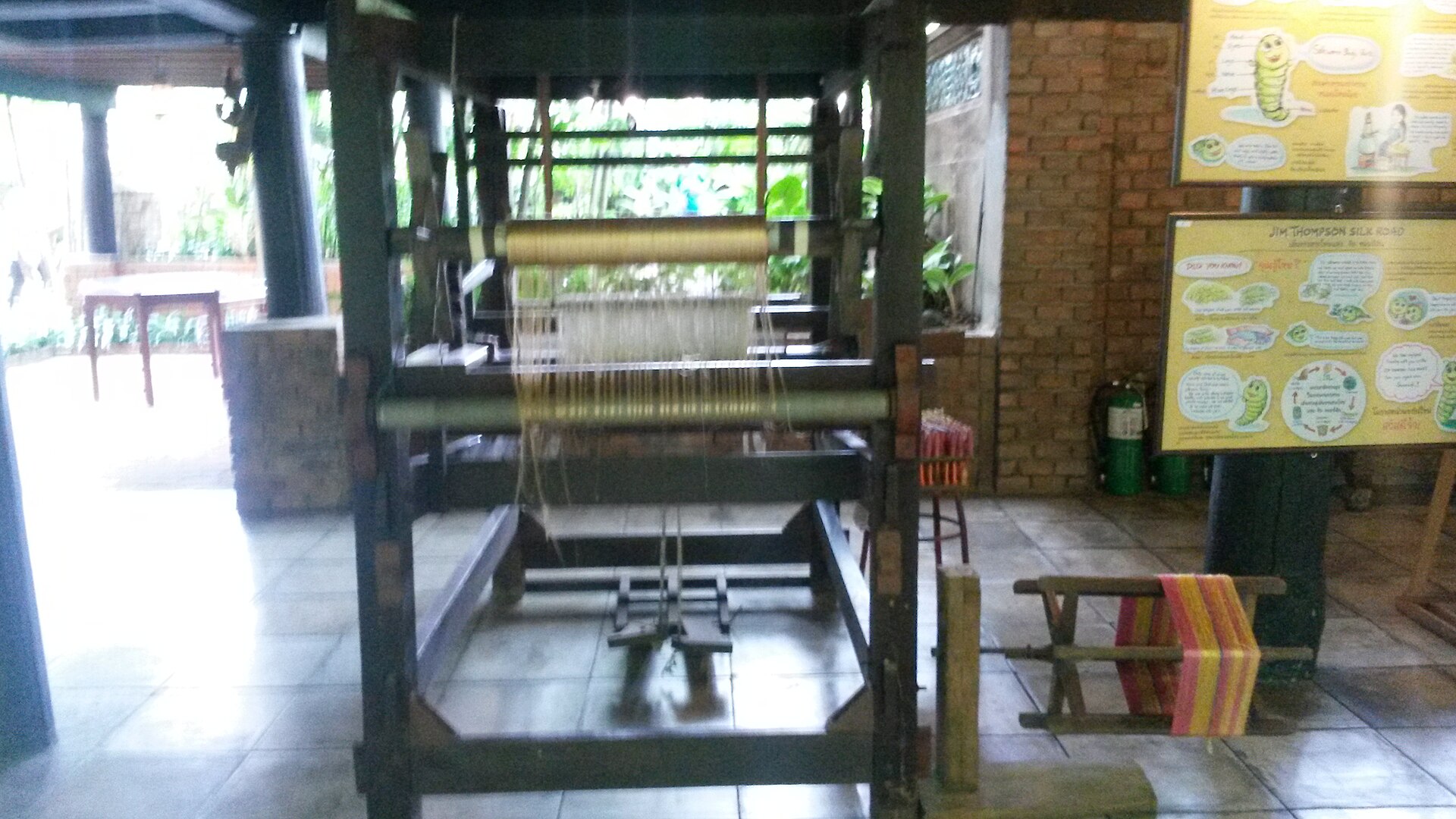 曼谷吉姆·汤普森故居展示的木制丝织机，经线垂直排列，脚踏板位于下方。