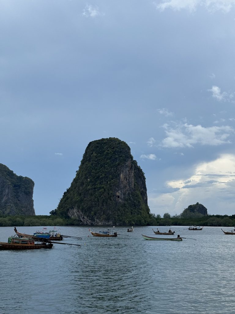巴蒙湾石灰岩岛峰前停着多艘长尾船