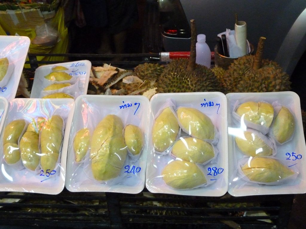 泰国街头摊位摆着整颗榴莲和多盒黄色榴莲果肉
