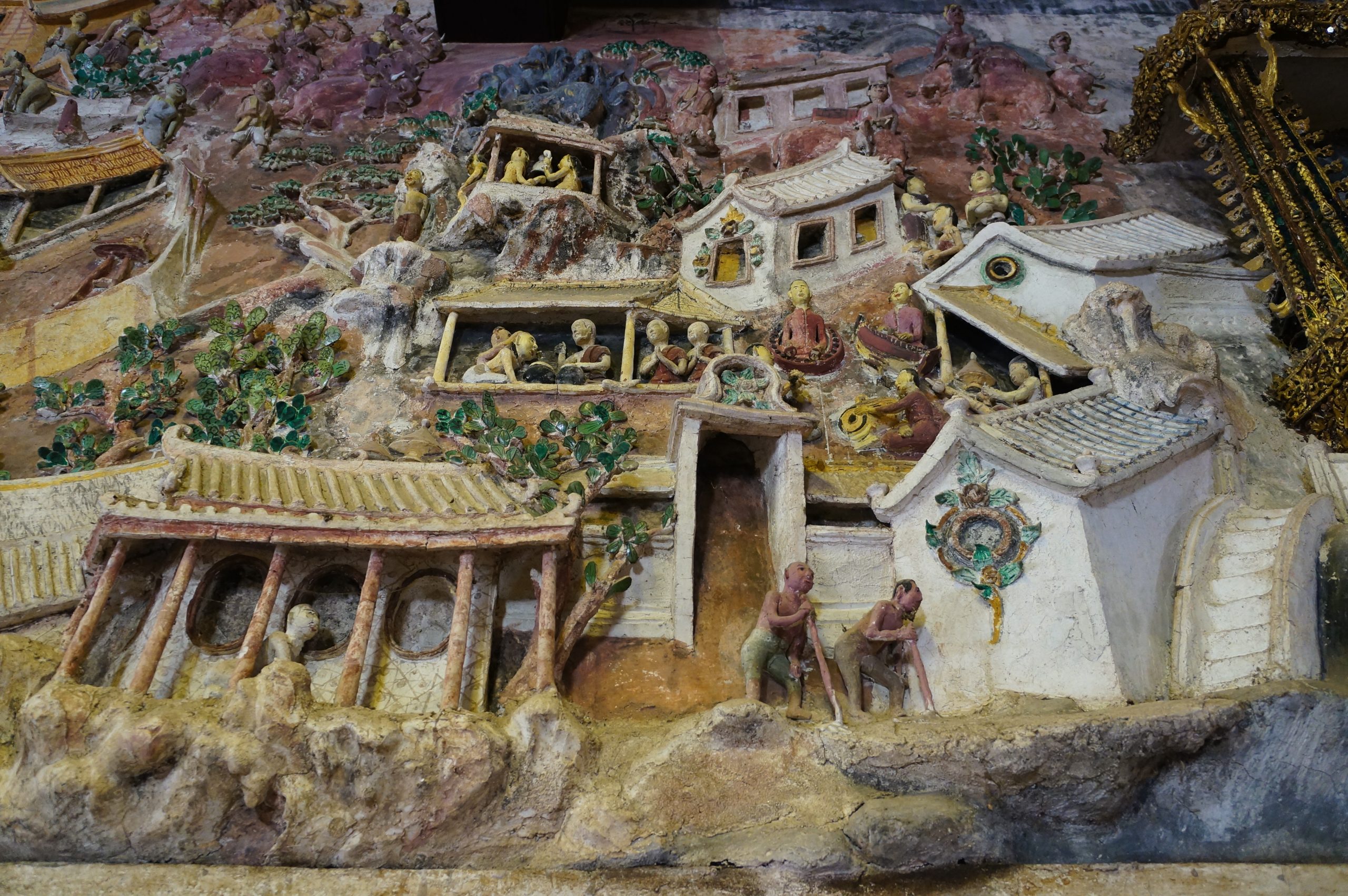 邦卡蓬寺灰塑中层叠的浅色屋顶圆窗柱廊人物和绿叶