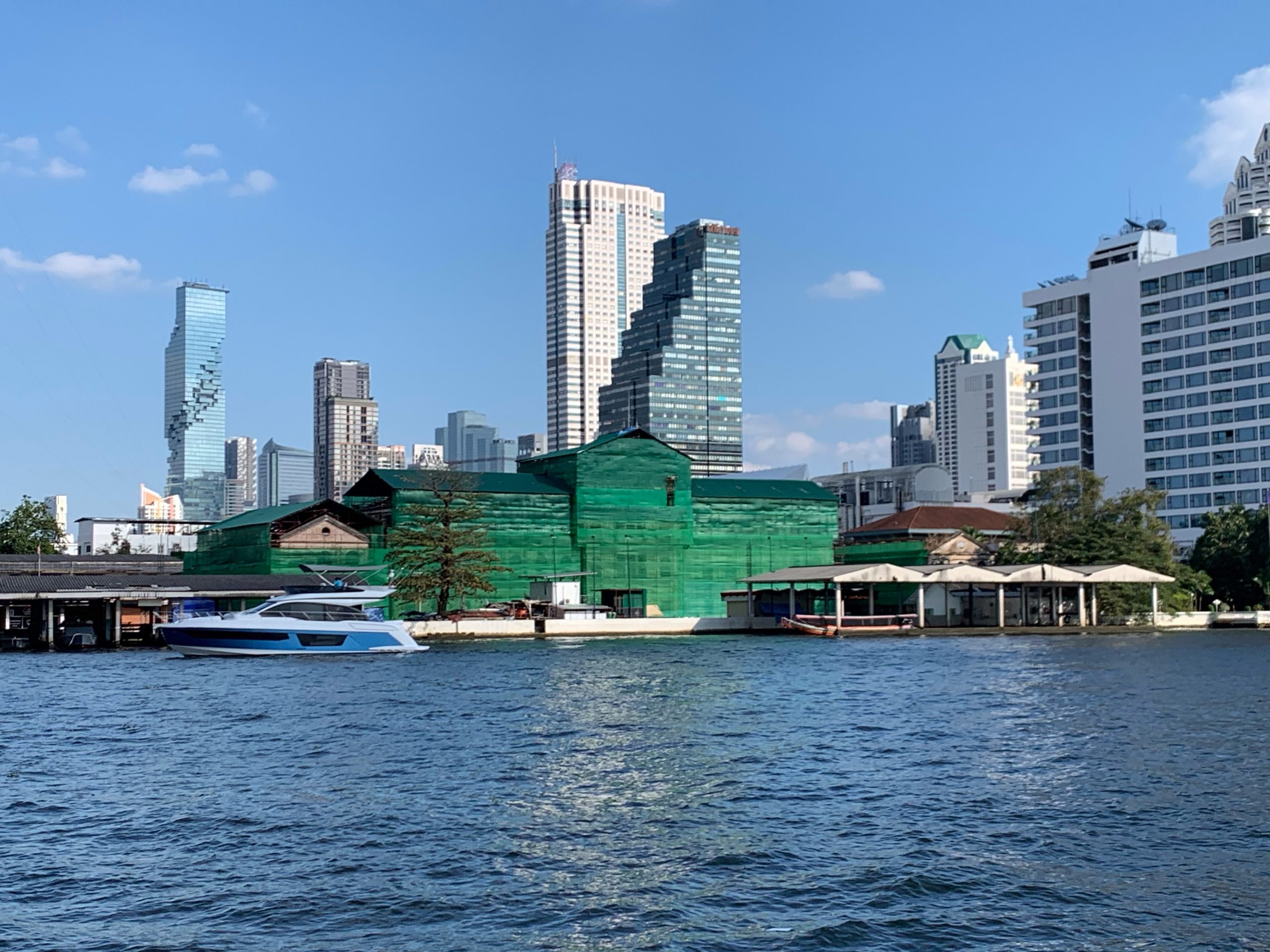 2022年1月,绿色防护网覆盖旧海关主楼,河面前有船,后方为高楼。