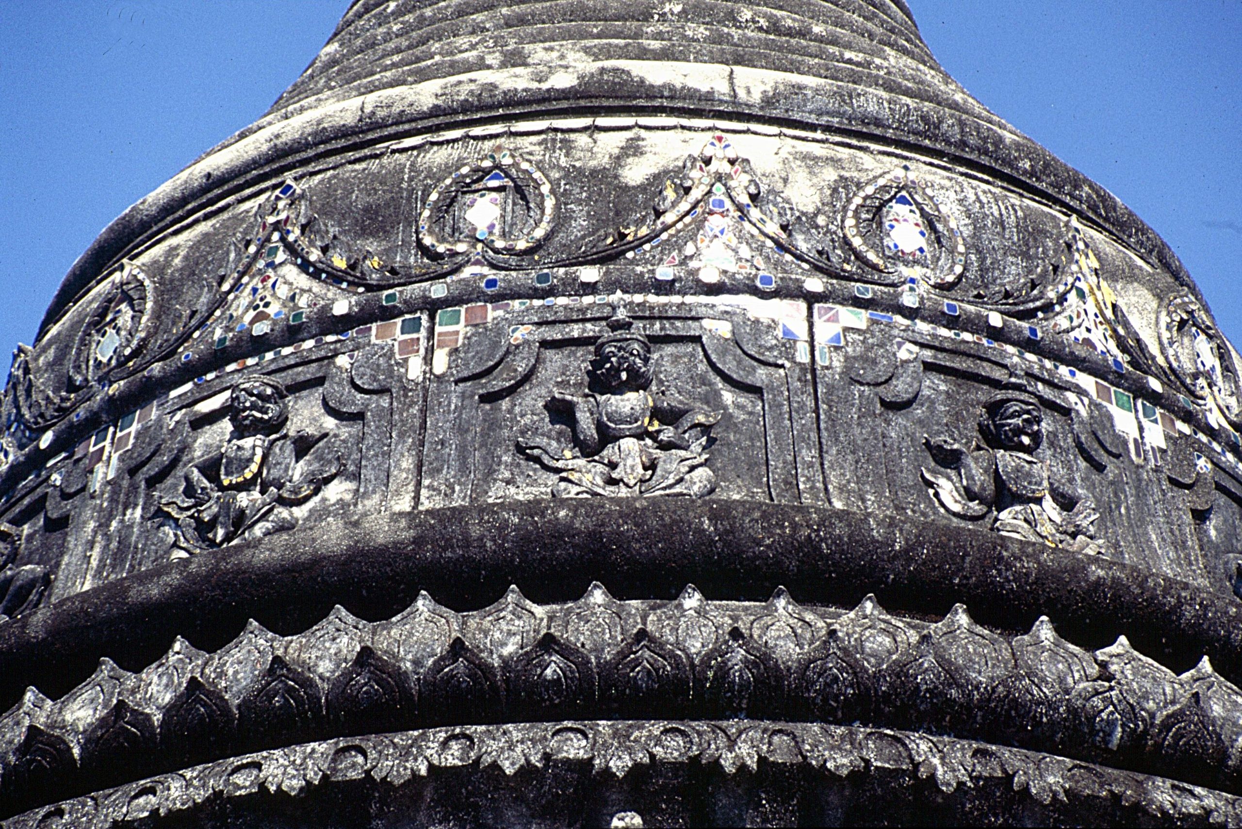 清迈 Wat Pa Pao 塔身局部,灰黑色线脚、拱形框内坐像和蓝绿白粉色装饰小片