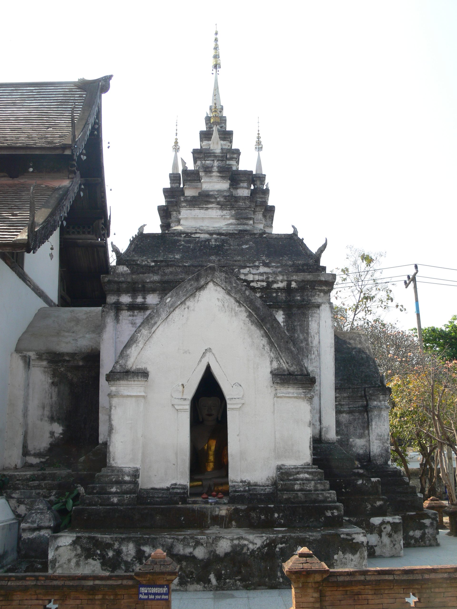清迈 Wat Prasat 木殿后方接合处，白色层叠尖顶、外侧尖拱佛龛与低矮连接白墙