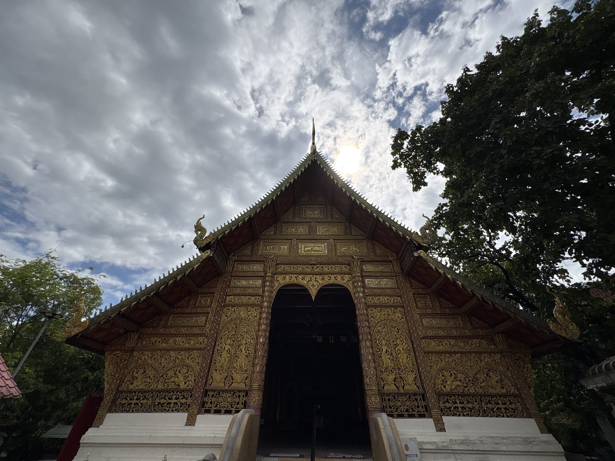 清迈 Wat Saen Fang 主殿正面,三角山墙内排列金色动物纹饰,下方是高门洞与白色台阶