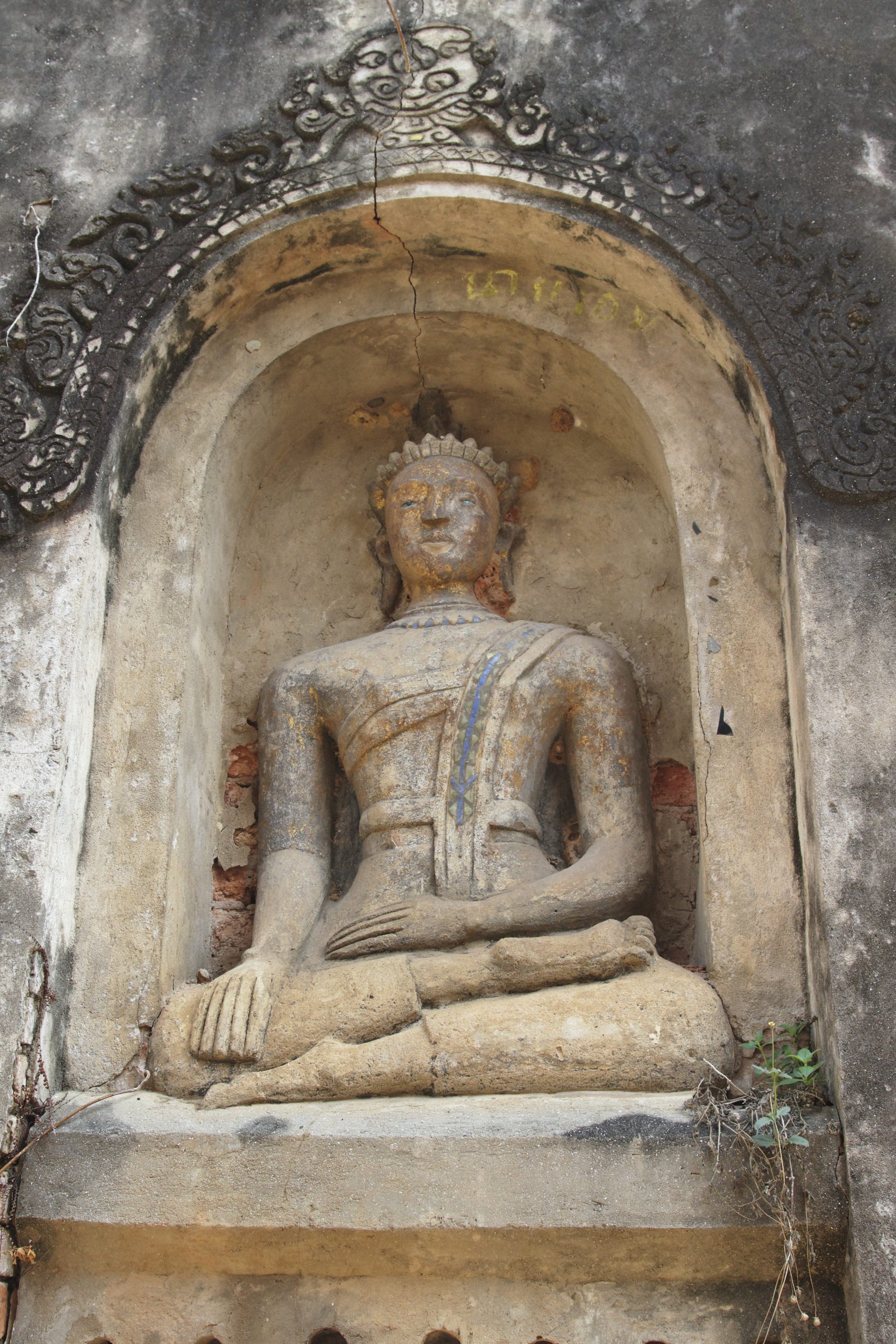 古帕科纳圆拱佛像壁龛,佛像斜披袈裟,周围可见裂缝和外露砖块