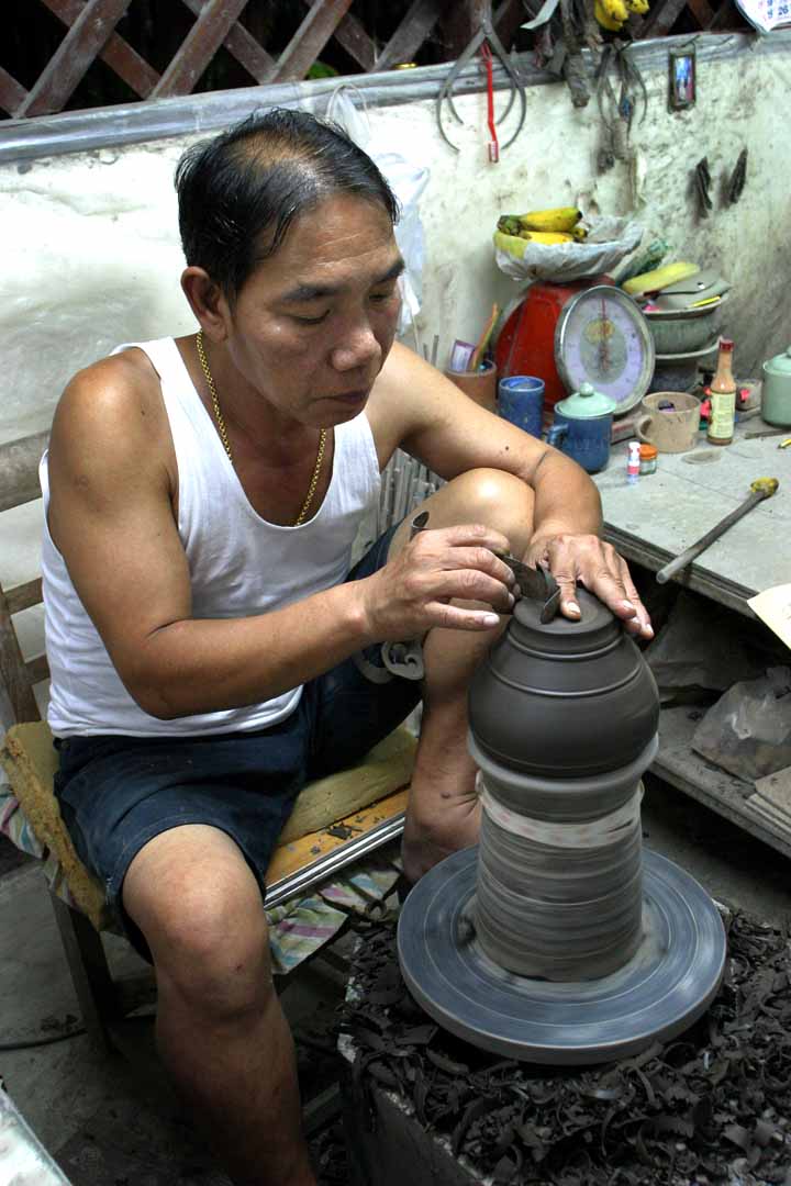 泰国陶工在手工转盘前成形