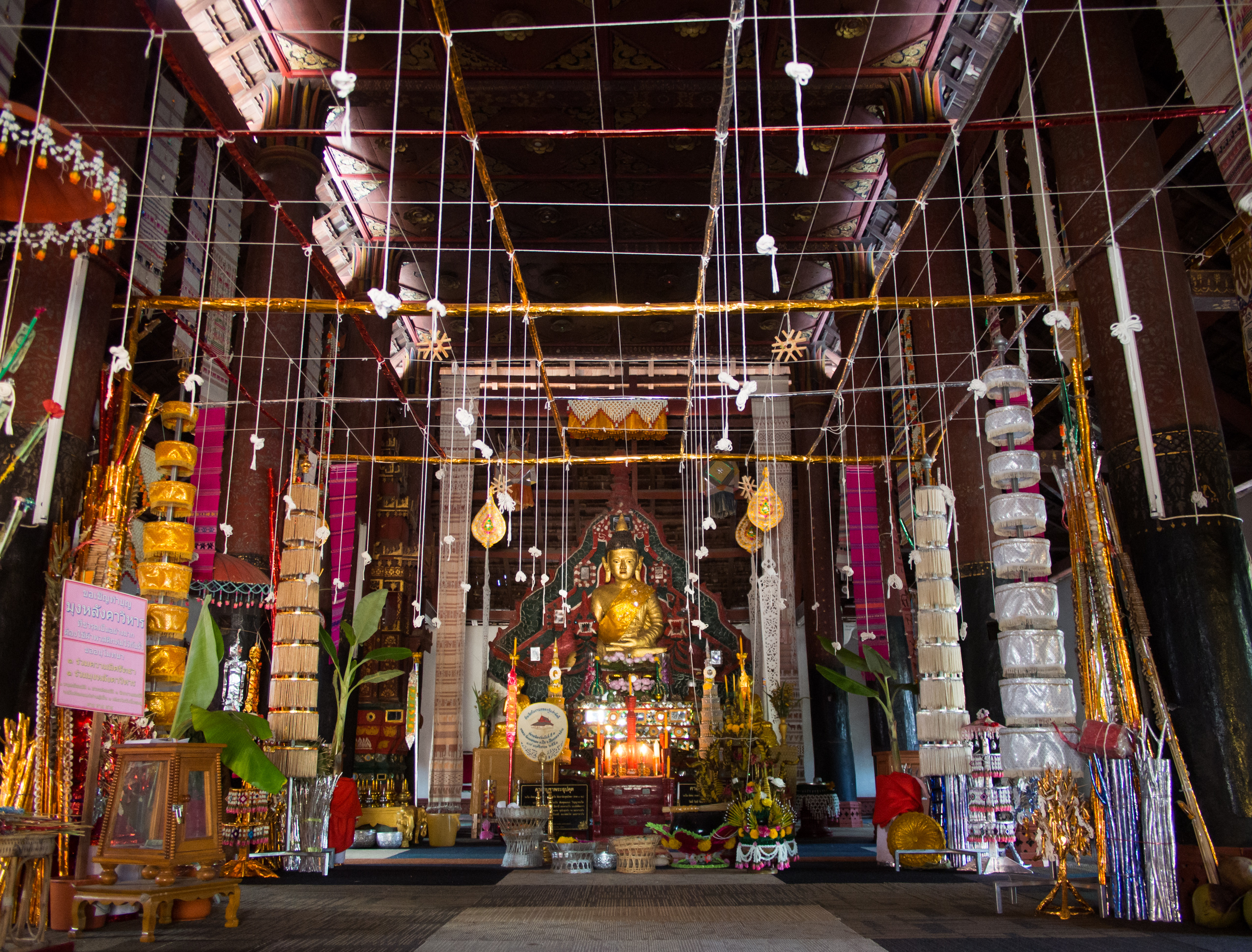楠府 Nong Daeng 佛殿内的主佛像、木柱、布幡与白色悬线