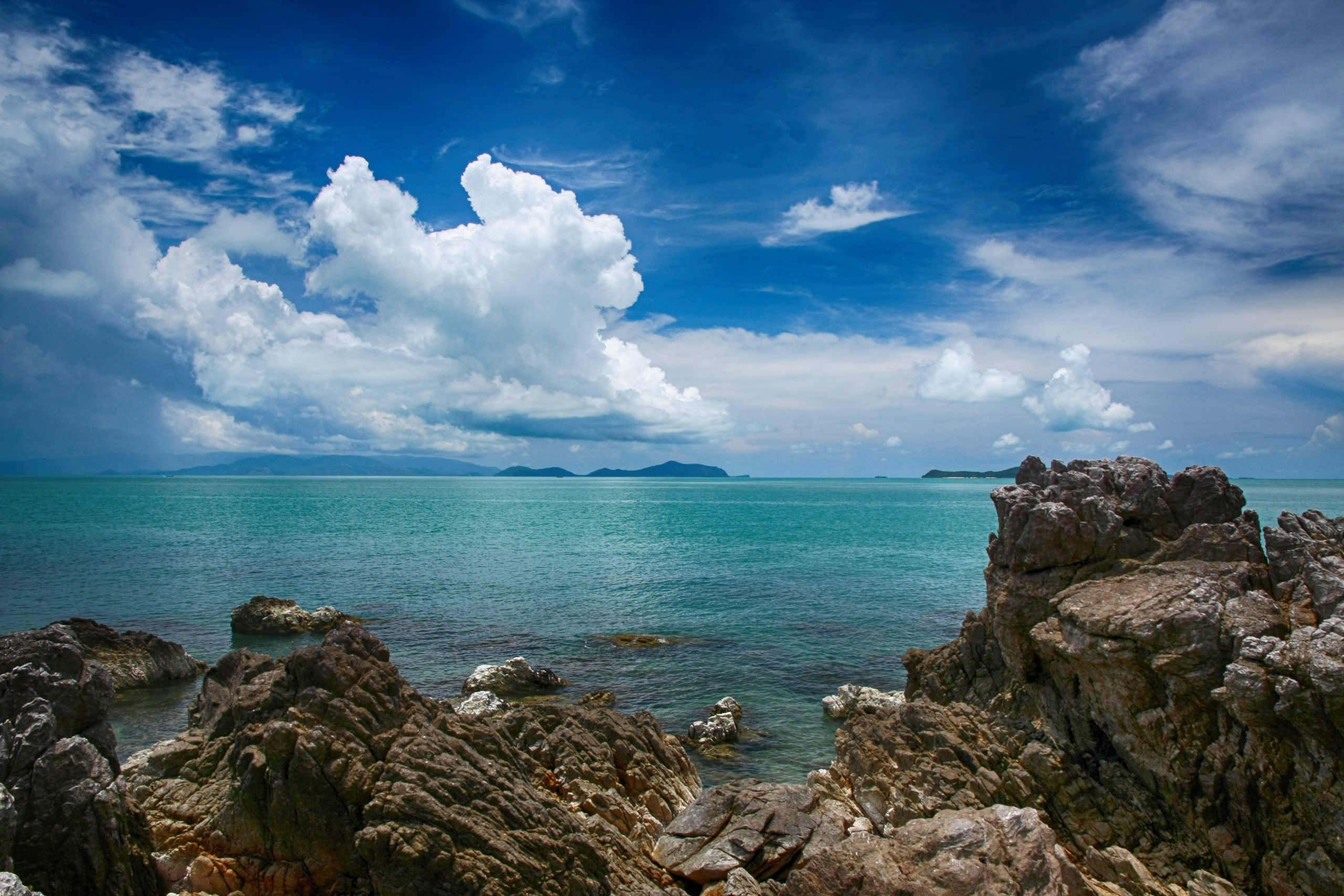 卡农海岸的岩石、海面与远处岛影。