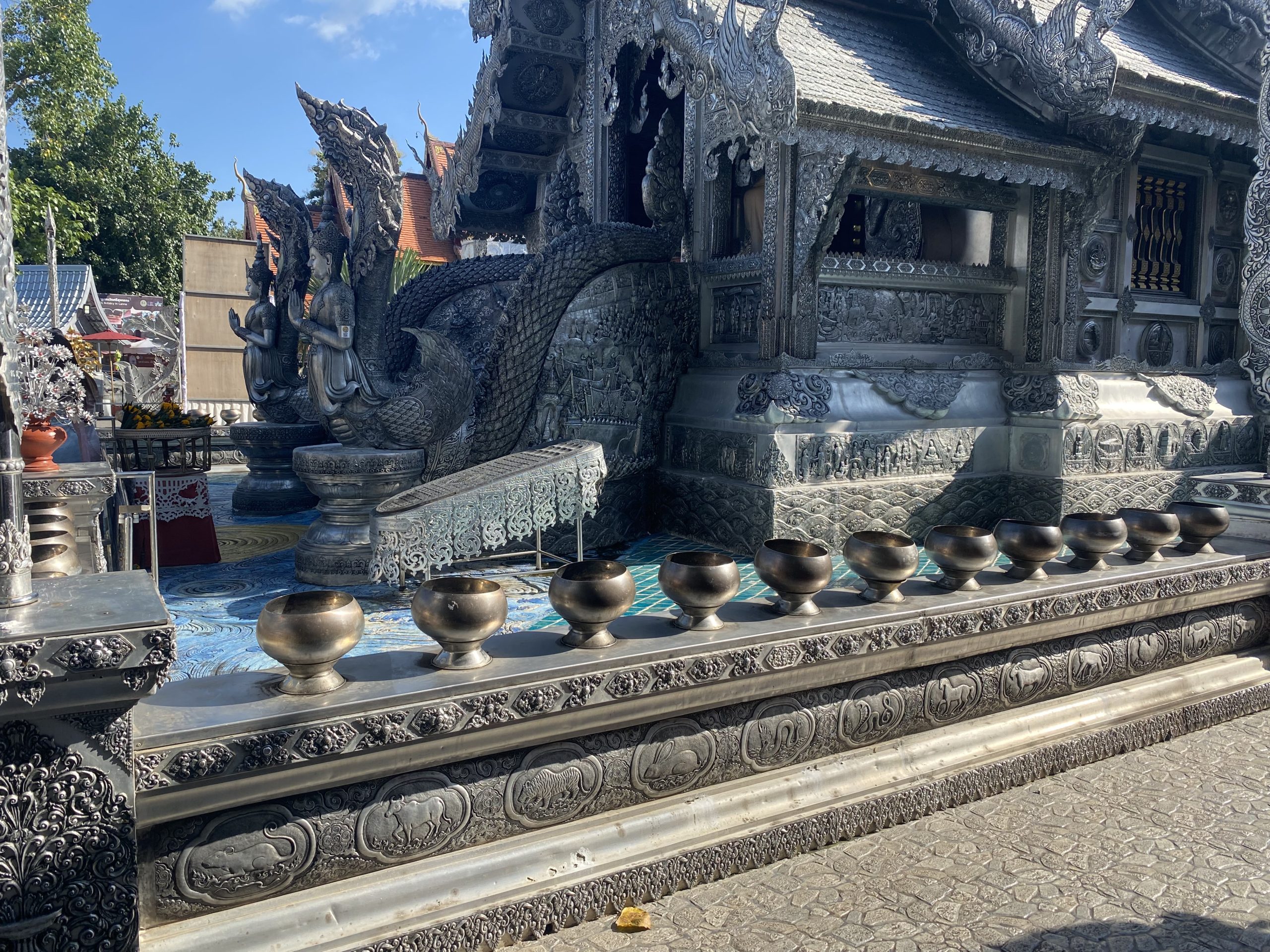 清迈Wat Sri Suphan银饰戒堂入口、阶梯前排列的钵和外墙浮雕。