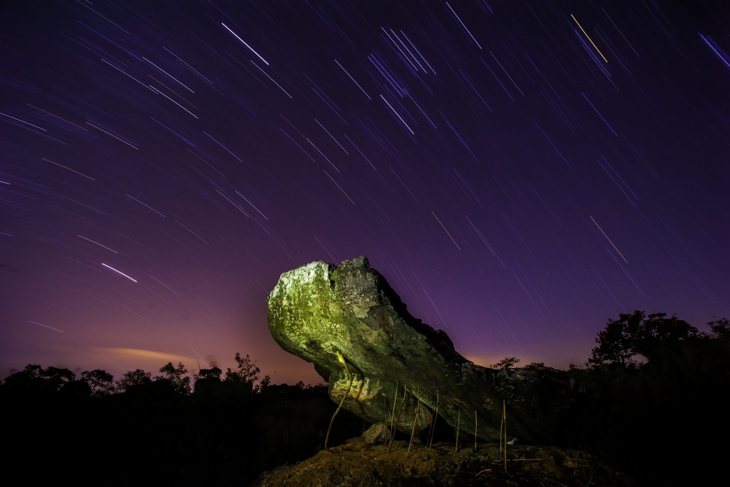 普考公园夜景中的岩石与细杆,天空有长曝光星轨