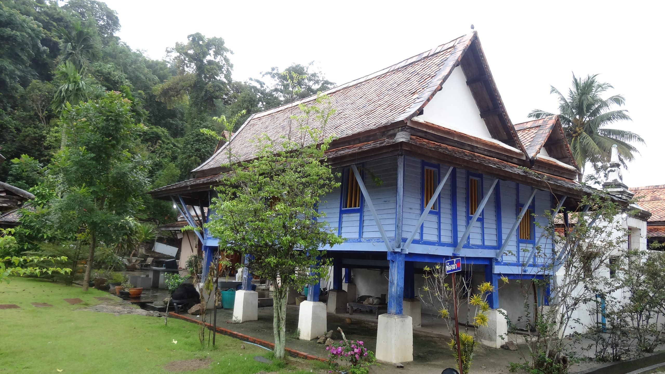 蓝色木屋架在柱脚上，斜撑向外托住低檐。